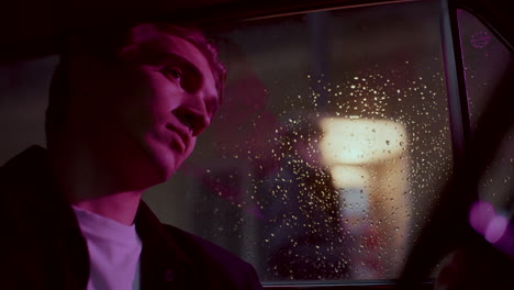 melancholic man sitting in car on rainy night, girl talking on payphone