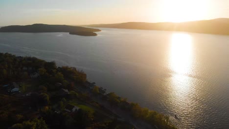 Slow-aerial-shot-showing-a-stunning-sunset-during-golden-hour-with-a-large-piece-of-land-right-below