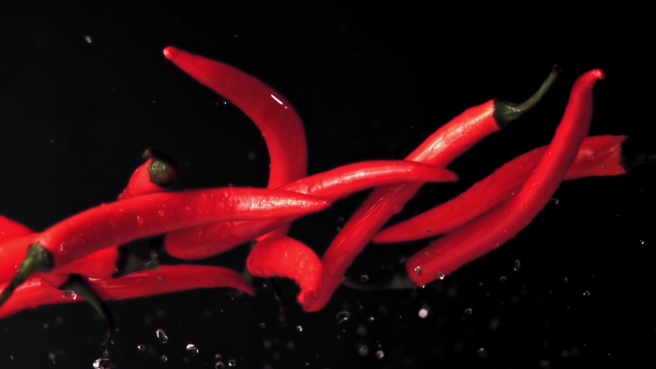 Red Chili Peppers Falling and Splashing with Water Droplets