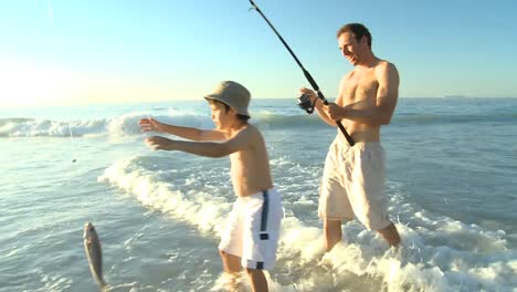 man fishing with his son on the beach