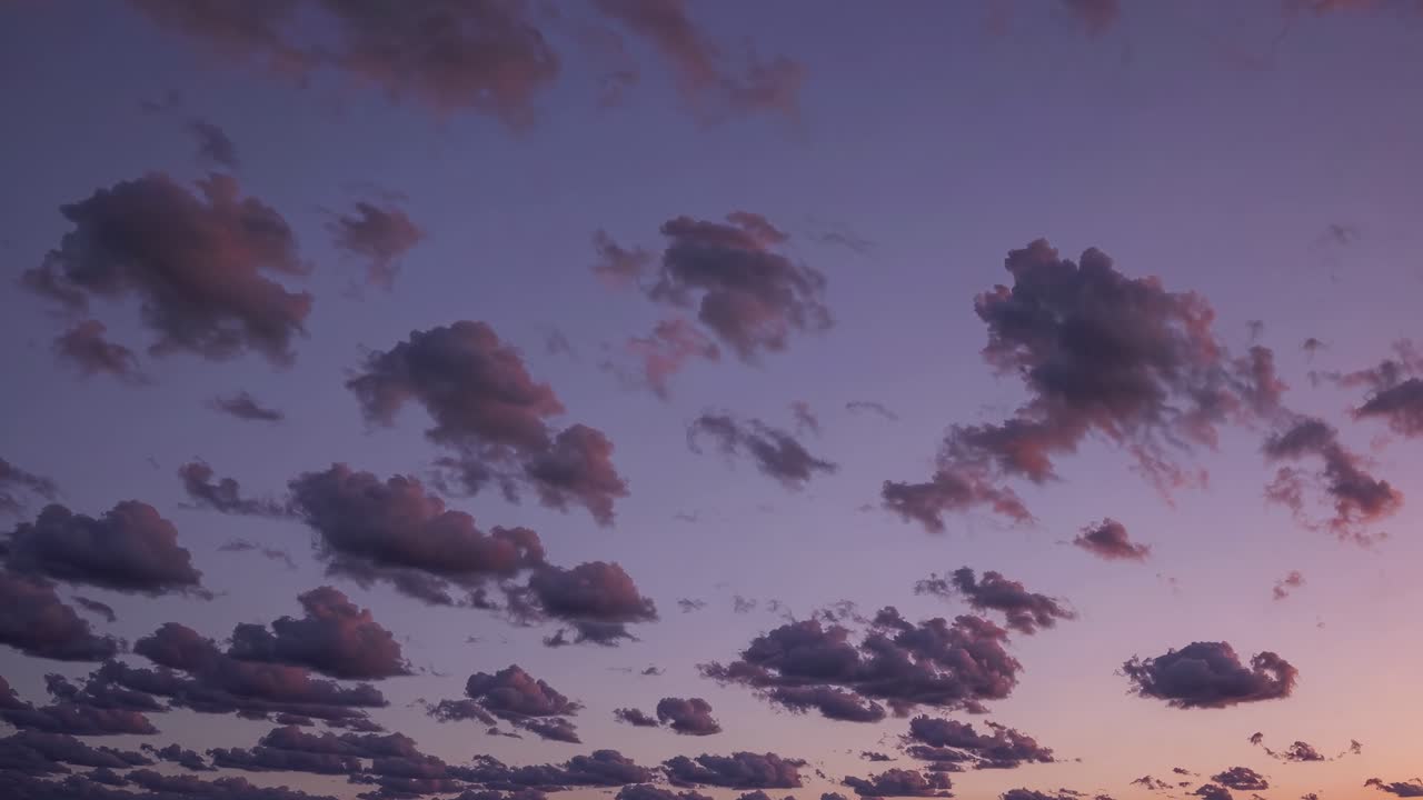 A serene sunset sky with scattered clouds, captured in a wide-angle view