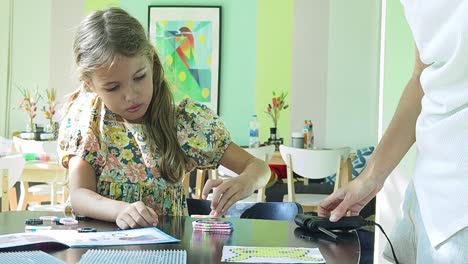 niña haciendo artesanía de mosaico con sus padres