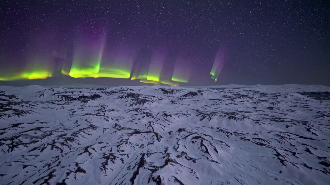 Aerial video captures the stunning Northern Lights over a snowy landscape, showcasing vibrant colors