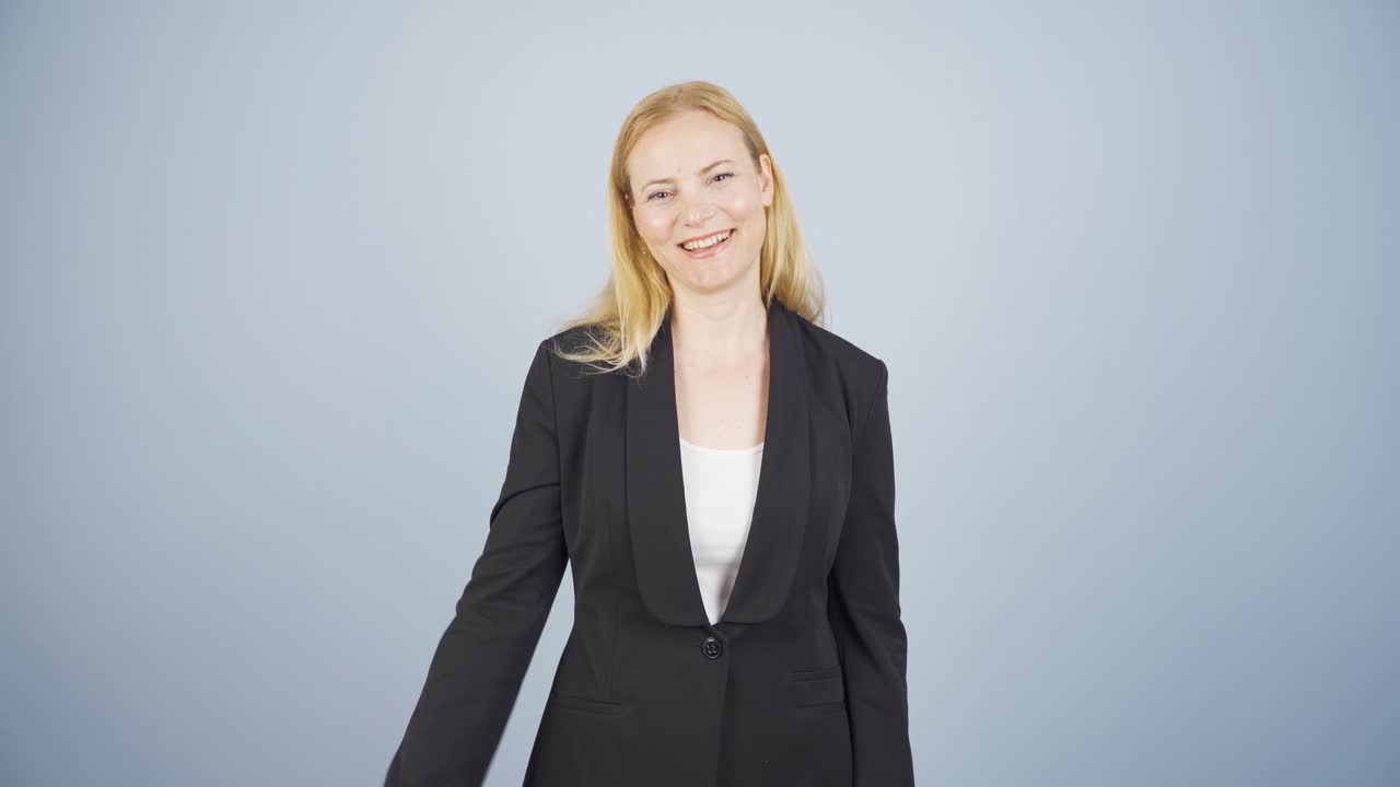 카메라를 향해 손을 흔들고 있는 사업가.