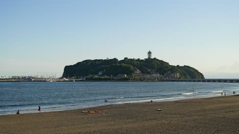 Spaziergang-Entlang-Der-Küste-Von-Enoshima-Mit-Halbinsel-In-Der-Ferne