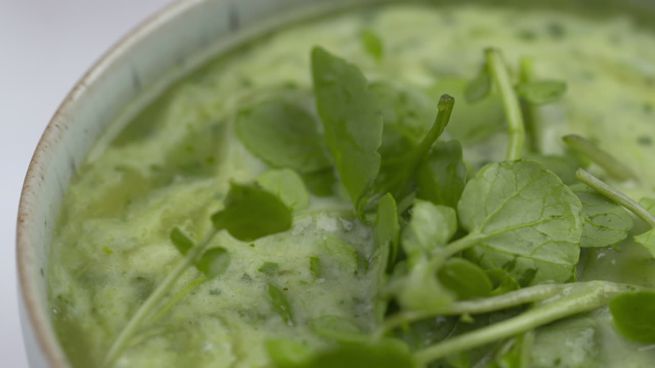 Watercress Soup Rotating In Blue Bowl With White Background. Healthy Lunchtime Recipe.Protein Plant Based Raw Vegan Food. Health And Vegetarian Foods. Healthy Ingredients. 4k Macro Food Shot