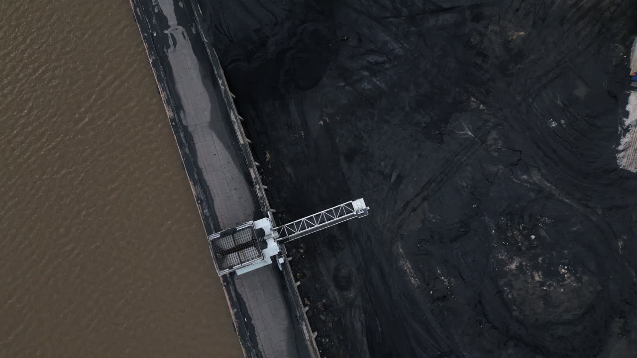 Top shot of a coal power plant's coal pile being emptied as the plant is shutting down