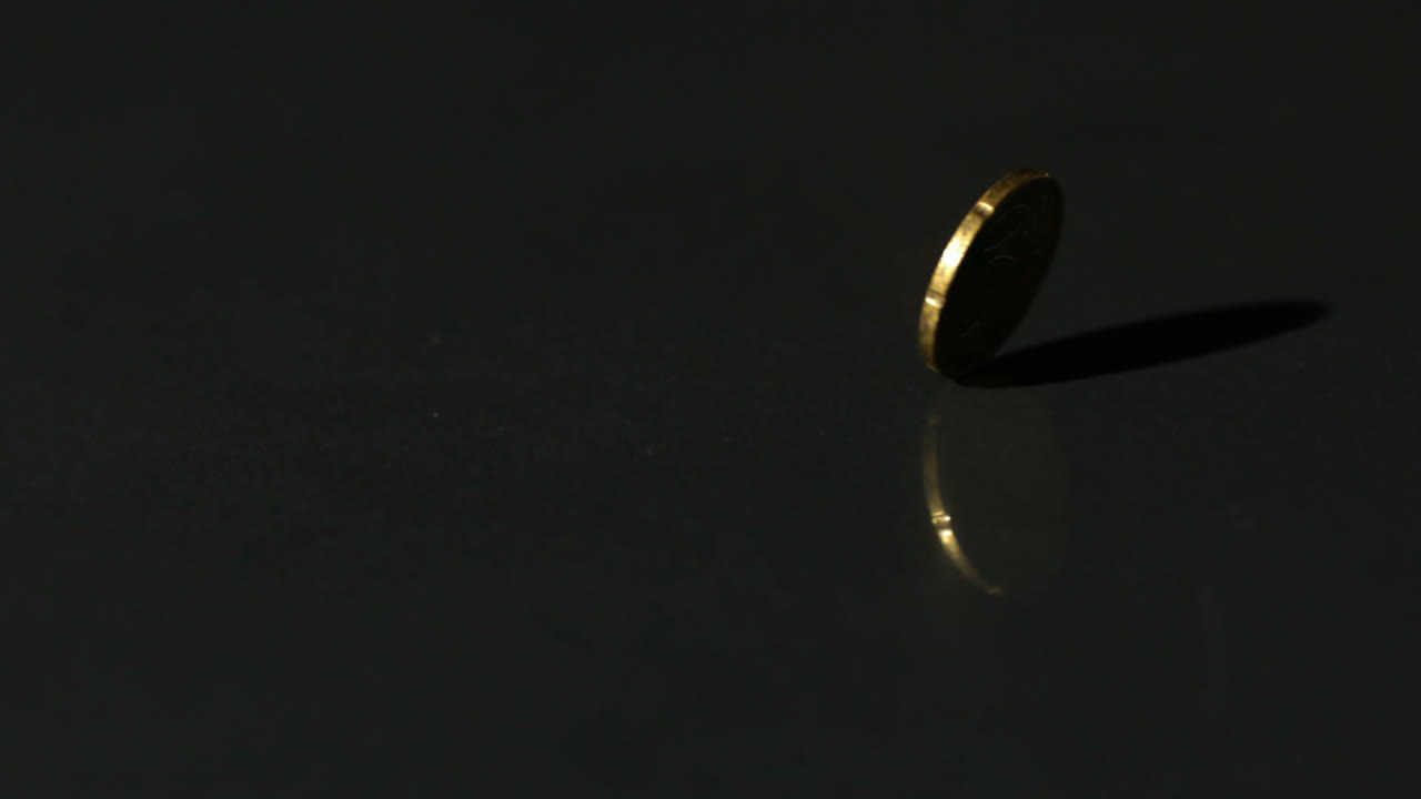 moneda de euro que gira sobre una superficie negra