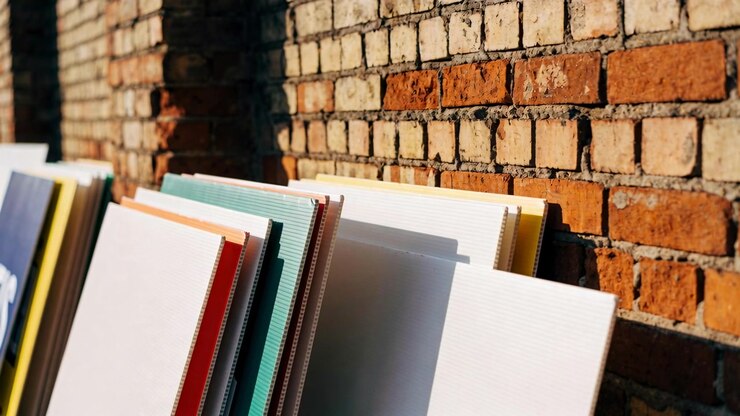 Panning camera revealing stacked canvases leaning in alley with colored spines and brick shadows