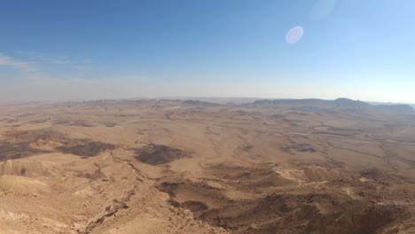 tilt up view of wild nature of negev desert in israel. crater canyon mitzpe ramon and summer sky. tourism and travel in middle east