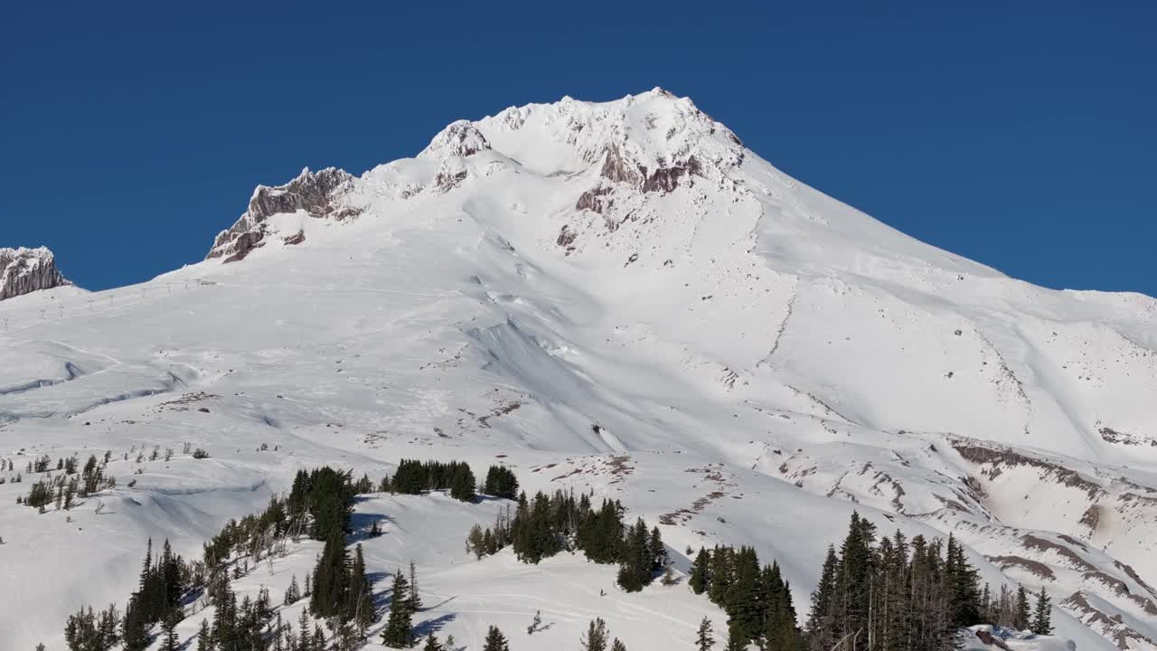 Vista aerea media in salita con drone del Monte Hood, dei suoi ghiacciai e della fitta coltre di neve sulla cima del vulcano solitario vicino al Timberline Resort nel Pacific Northwest, nei pressi di Hood River e Portland, Oregon