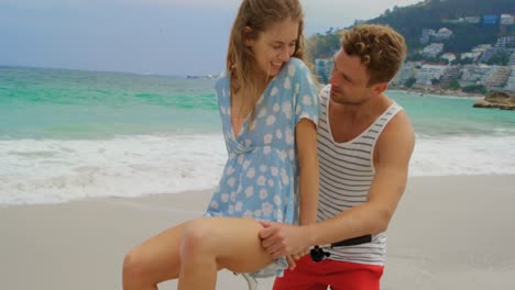 front view of caucasian couple sitting on a bicycle at beach 4k