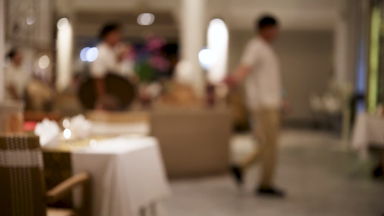 역동적 인 움직임 과 따뜻 한 조명 을 특징 으로 하는 웨이트 스태프 와 후원자 들 이 있는 활기찬 레스토랑