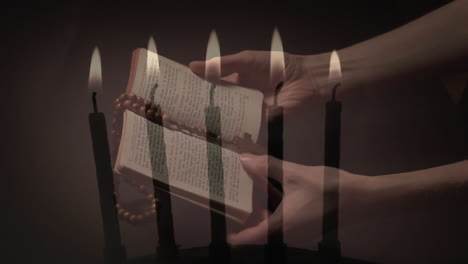 video compuesto de velas encendidas contra las manos de la mujer sosteniendo la biblia y el rosario orando