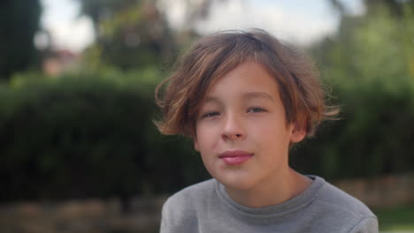 retrato de un niño adolescente en el parque verde