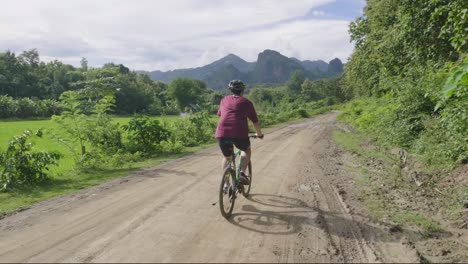 man mountain biking through countryside
