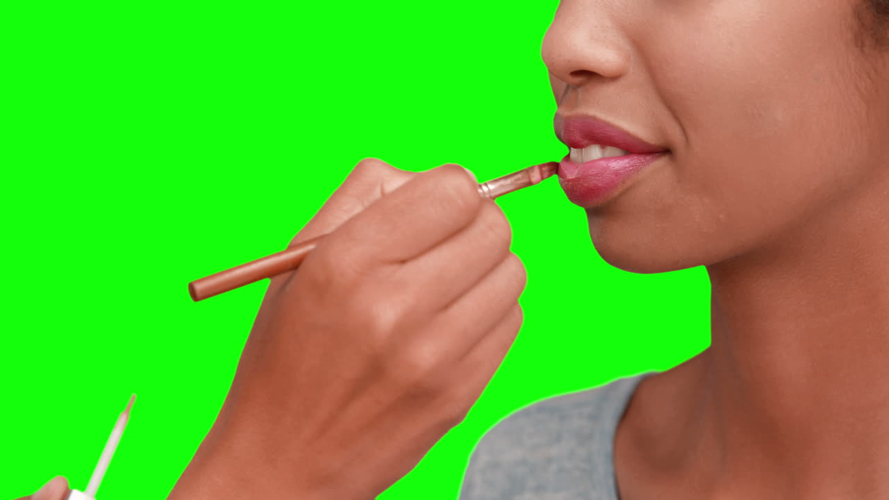 artista de maquillaje poniendo brillo para los labios en la cara de las modelos