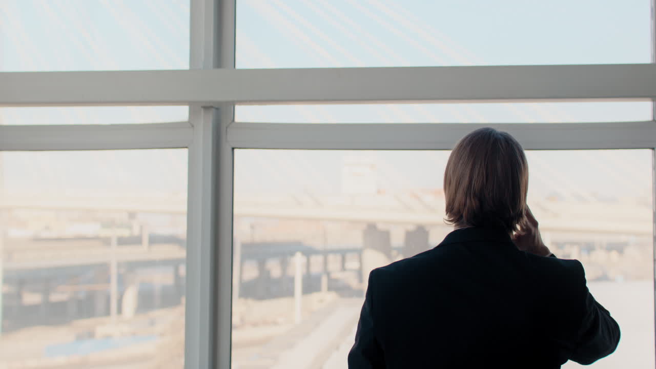 Businessman talking on phone at window