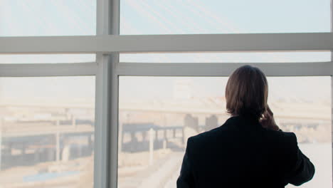 businessman talking on phone at window