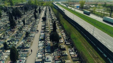 Vista-Aérea-De-Un-Cementerio-Vecino-A-Una-Autopista-De-Varios-Carriles