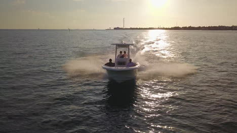 friends riding on a center console at full speed near key west florida during sunset