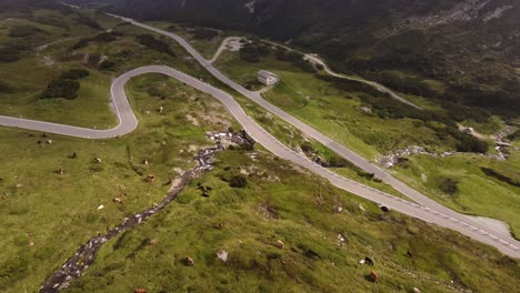 4K-Drohnenaufnahmen-Fangen-Die-Natürliche-Schönheit-Der-Schweizer-Alpen-Ein,-Während-Die-Sonne-Am-Gotthardpass-Durch-Die-Wolken-Untergeht