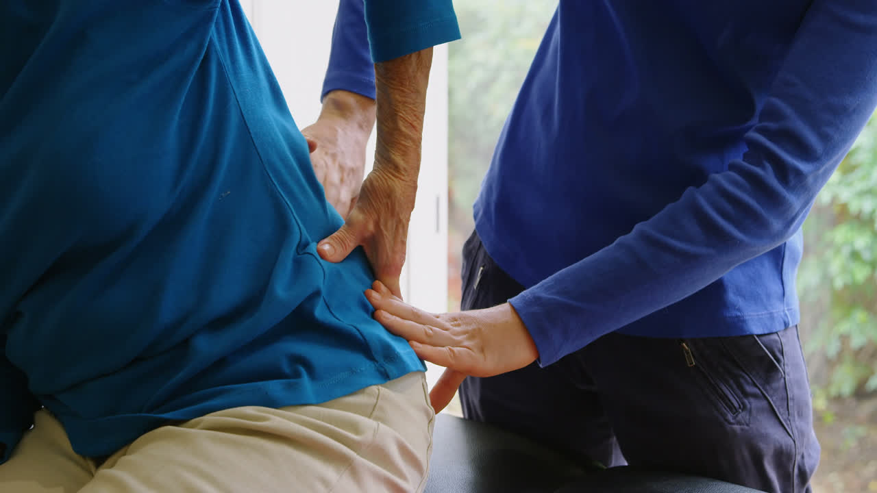 피지오테라피스트가 4k 클리닉에서 노인 여성을 검사하고 있습니다.