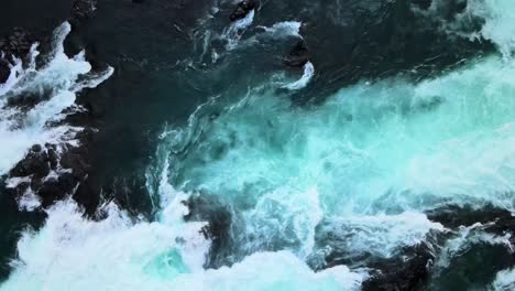 Overhead-dolly-out-view-of-the-blue-waters-of-the-Saltos-del-Petrohue,-southern-Chile