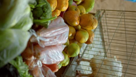 live native chickens on cage and vegetables for sale at the african market