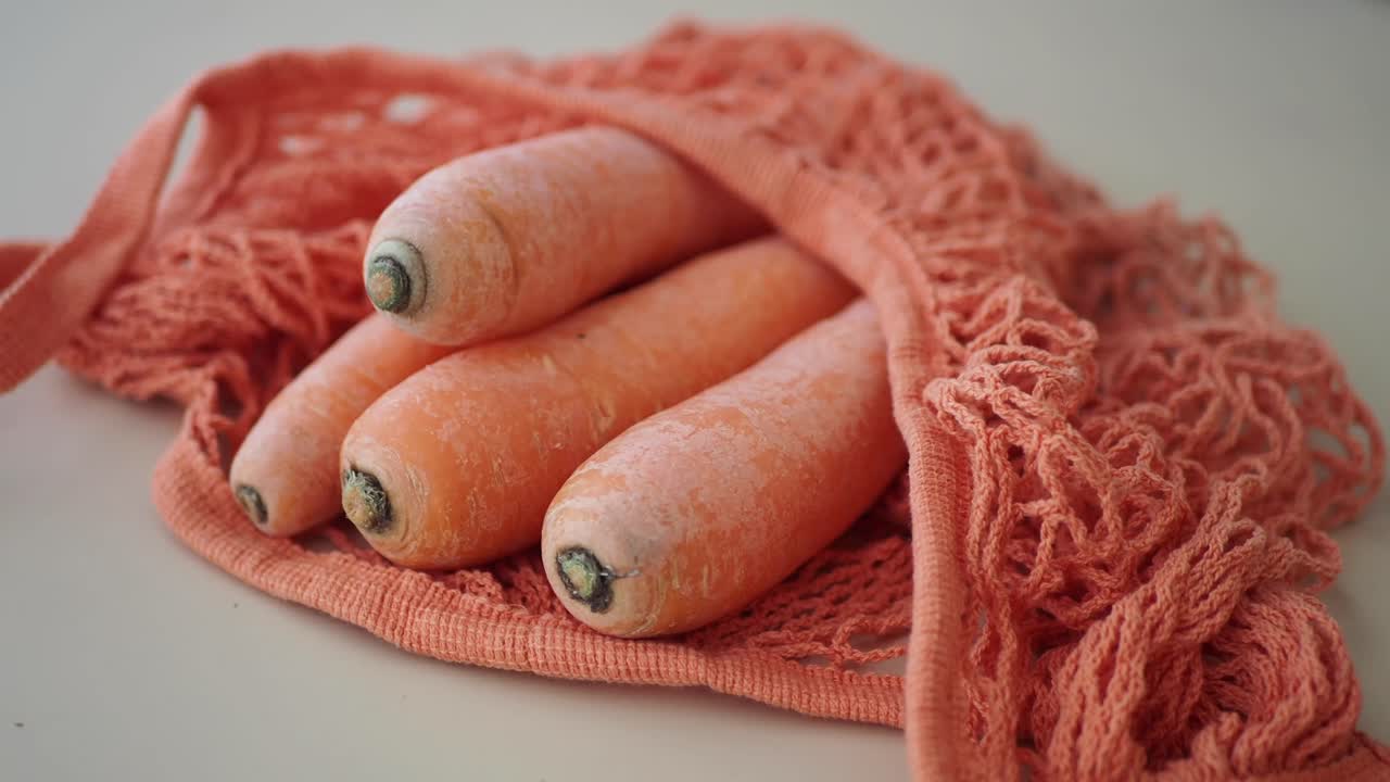 Carote fresche in un sacchetto a rete riutilizzabile