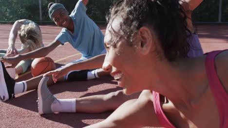 Feliz-Y-Diverso-Equipo-Femenino-De-Baloncesto-Entrenando-En-Una-Cancha-Soleada,-En-Cámara-Lenta