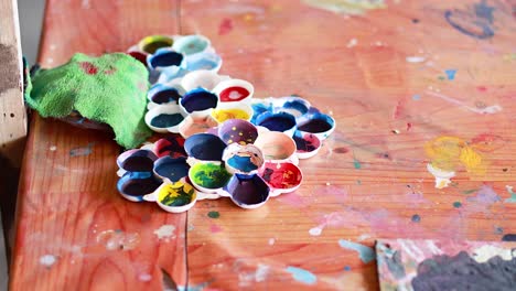 paint palette and canvas on a messy desk