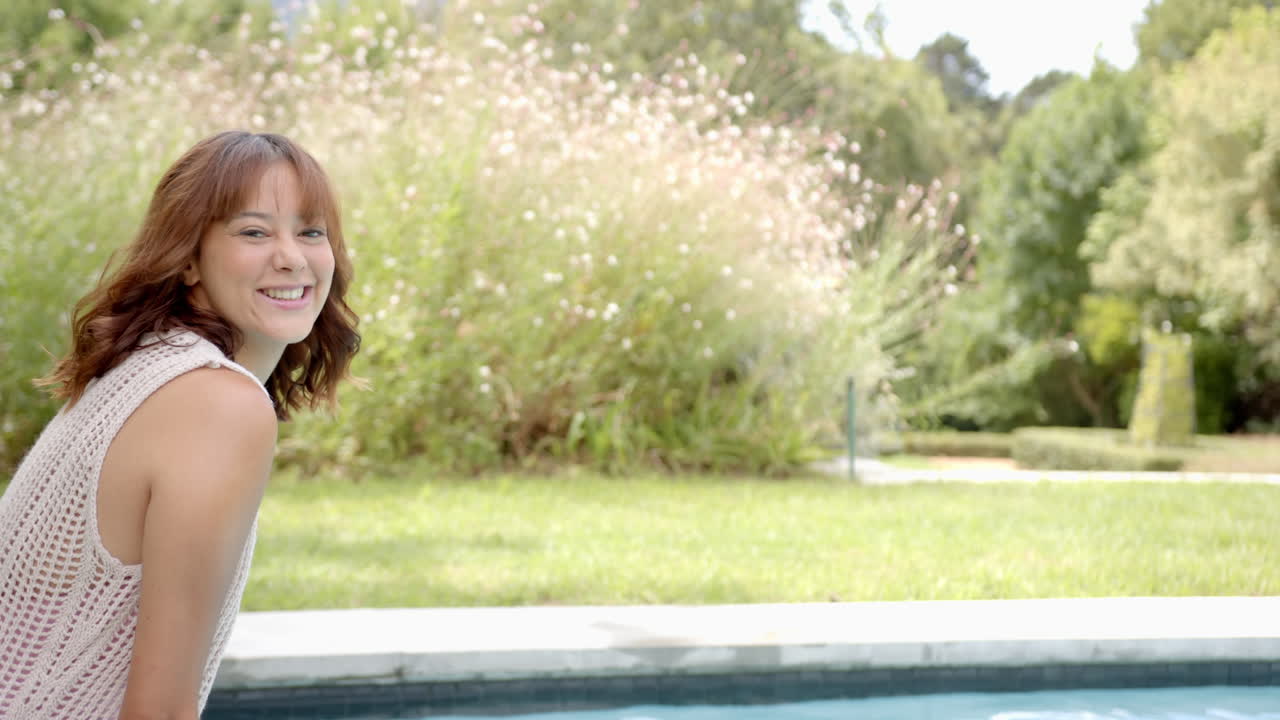 Sitting by poolside, smiling woman enjoying sunny day outdoors, copy space