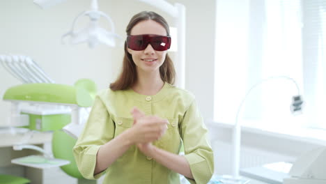 Young-doctor-dressing-up-dental-protective-glasses-in-dentist-office