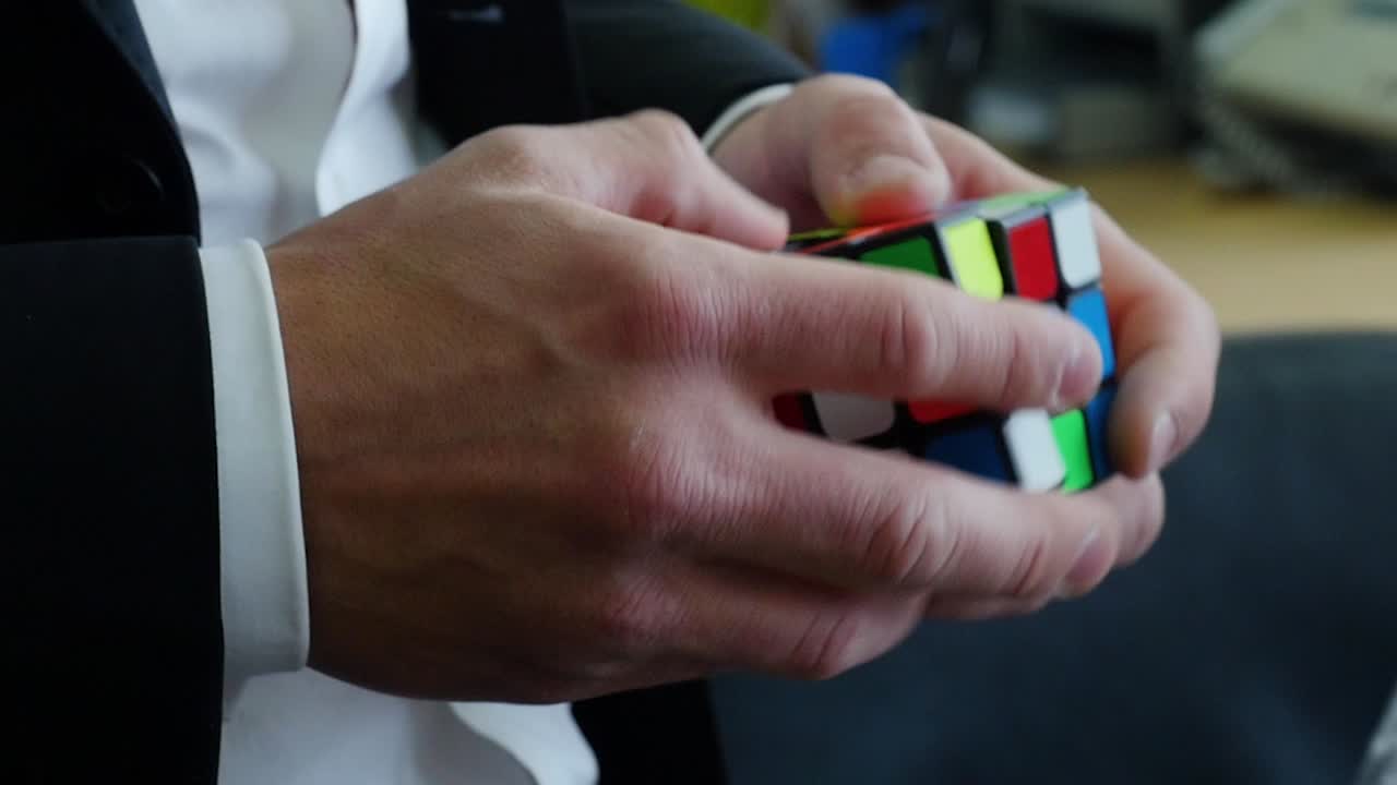 persona que está resolviendo un cubo de rubix