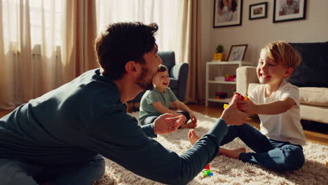 father and children playing with toys in the living room
