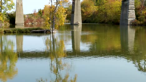 Wind-Kräuselt-Sanft-über-Das-Wasser-Vor-Den-Stützen-Einer-Überkopfbrücke