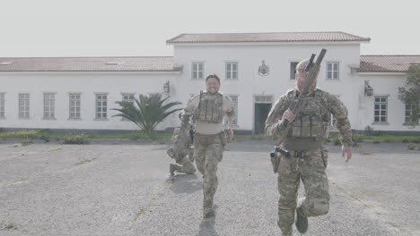 soldiers with rifles running together for cover