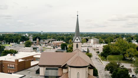 parallax drone video of catholic church on a cloudy summer day surrounded by the city of little chute, wisconsin