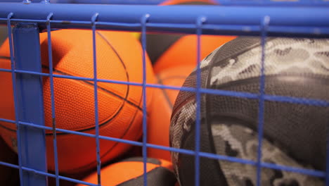 large basket full of a variety of basketballs