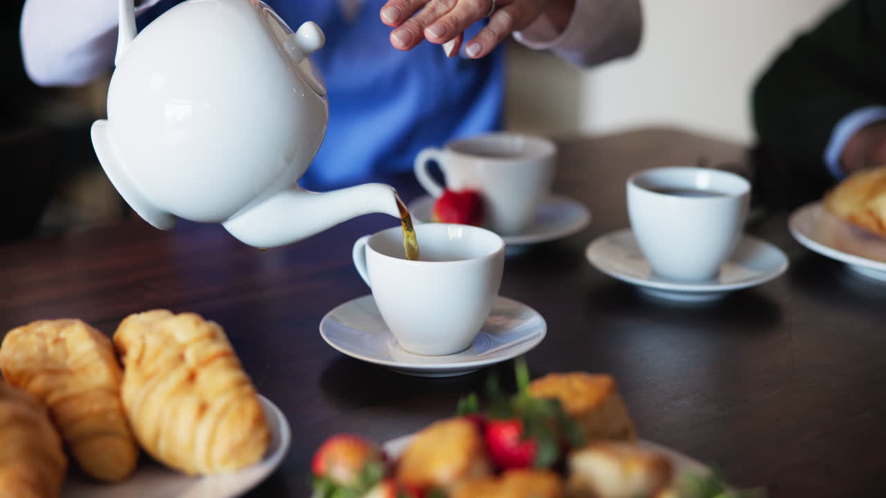 A group of people enjoying a cup of tea and pastries