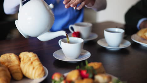 a group of people enjoying a cup of tea and pastries