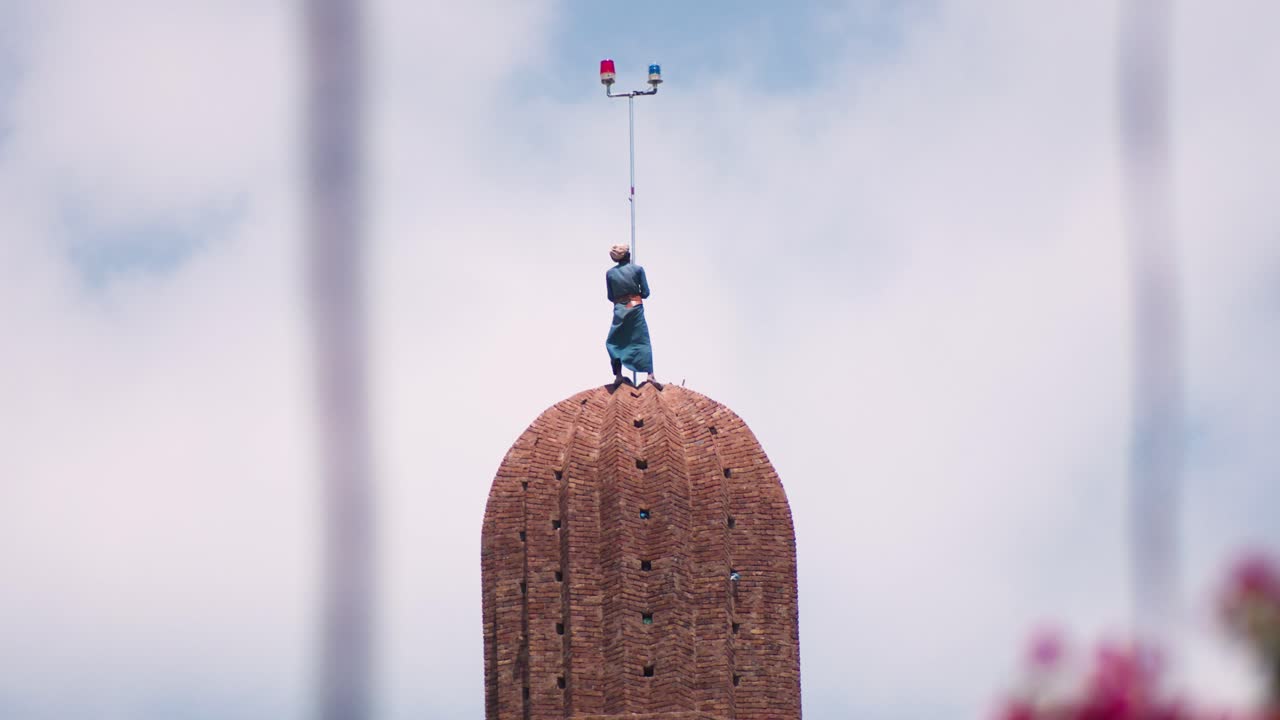 미나렛 꼭대기에 있는 남자를 위한 망원 샷은 안전 장비 없이 끝 초승달을 마무리합니다.