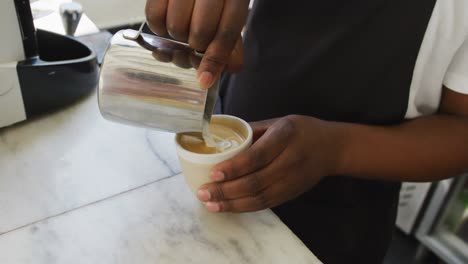 Close-up-of-african-american-male-barista-making-coffee-at-cafe