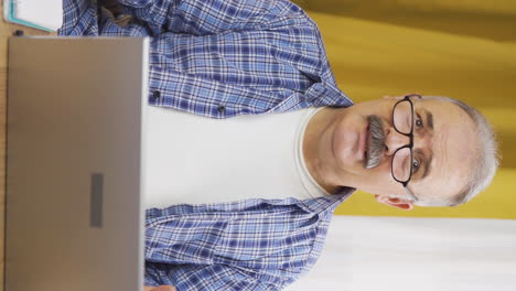 Vertical-video-of-Old-man-looking-at-laptop-gets-frustrated.