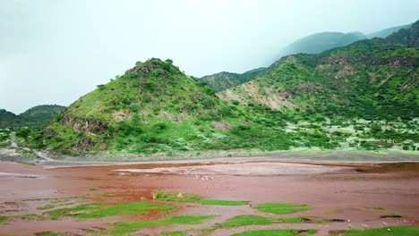 Beautiful-Landscape-Of-Lake-Natron-With-Tourists-Swimming-In-The-Water-In-Tanzania---aerial-drone-shot