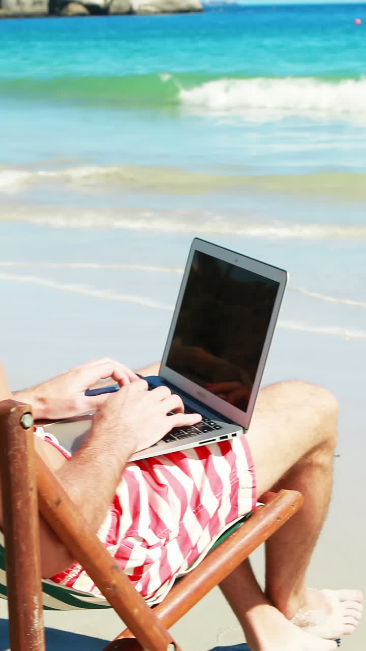 hombre usando una computadora portátil en la playa