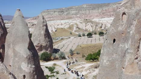 jinetes con caballos caminando por el paisaje de toba del sitio del patrimonio mundial de la unesco goreme, capadocia, anatolia central, turquía, asia