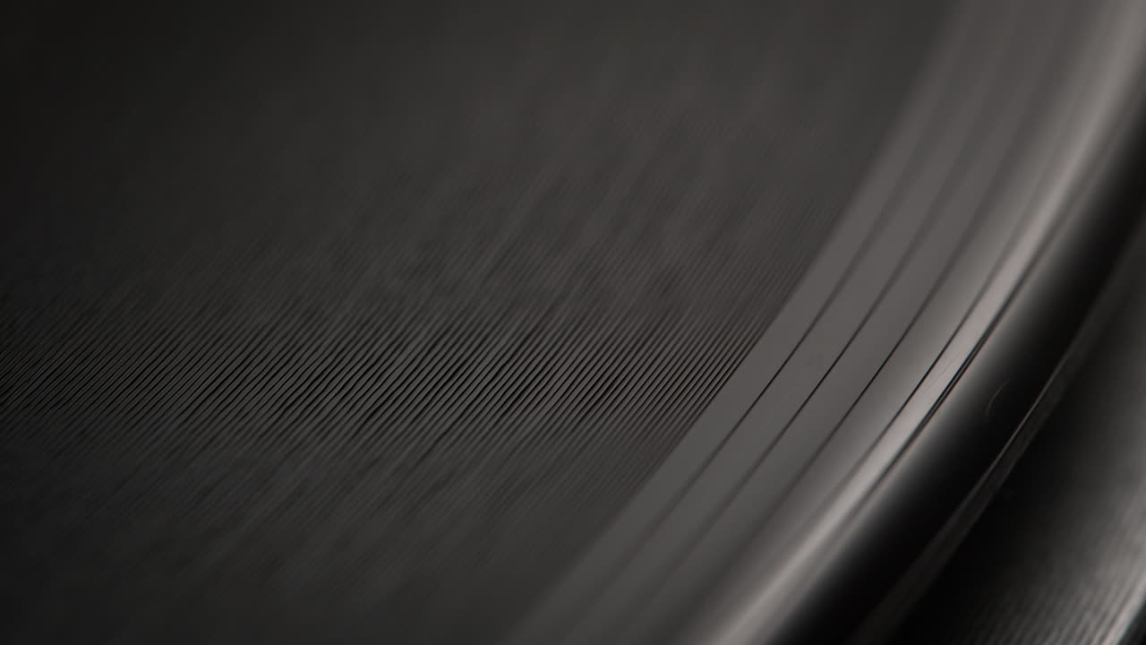 borde exterior y ranuras de un disco de vinilo giratorio en el tocadiscos en macro y cámara lenta