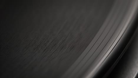 outer edge and grooves of a spinning vinyl record on the turntable in macro and slow motion